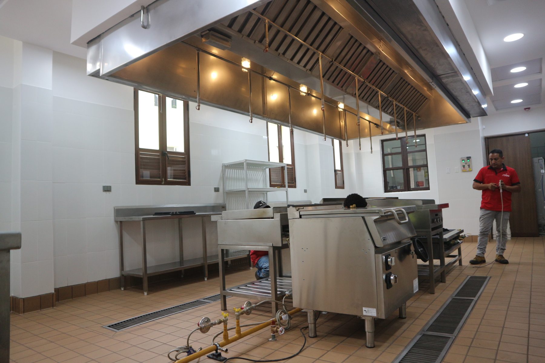 Cocina del comedor de Agripac con campana de extracción y línea de cocción