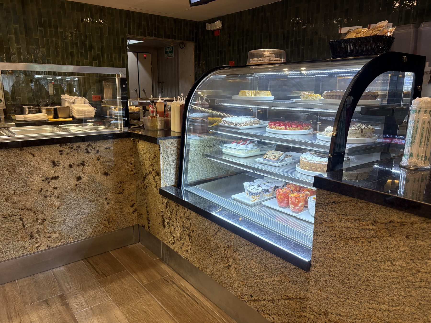 Vitrina refrigerada de postres sobre mesón de granito