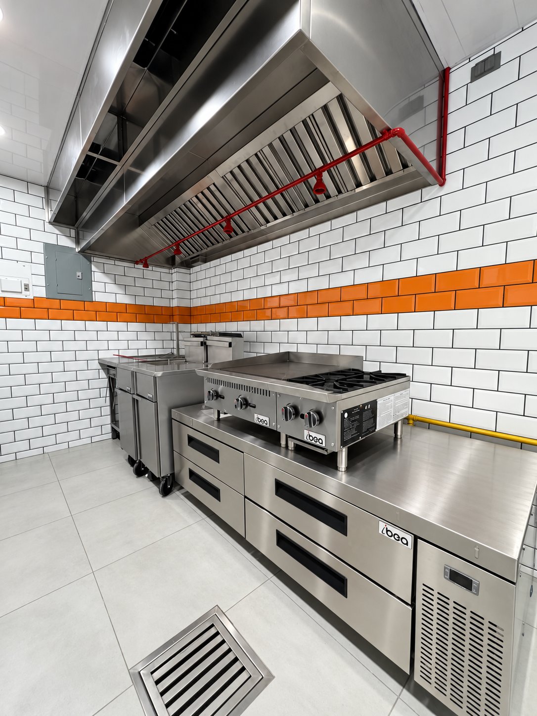 Plancha y cocina Ibea sobre base de chef refrigerada, freidoras y campana de extracción