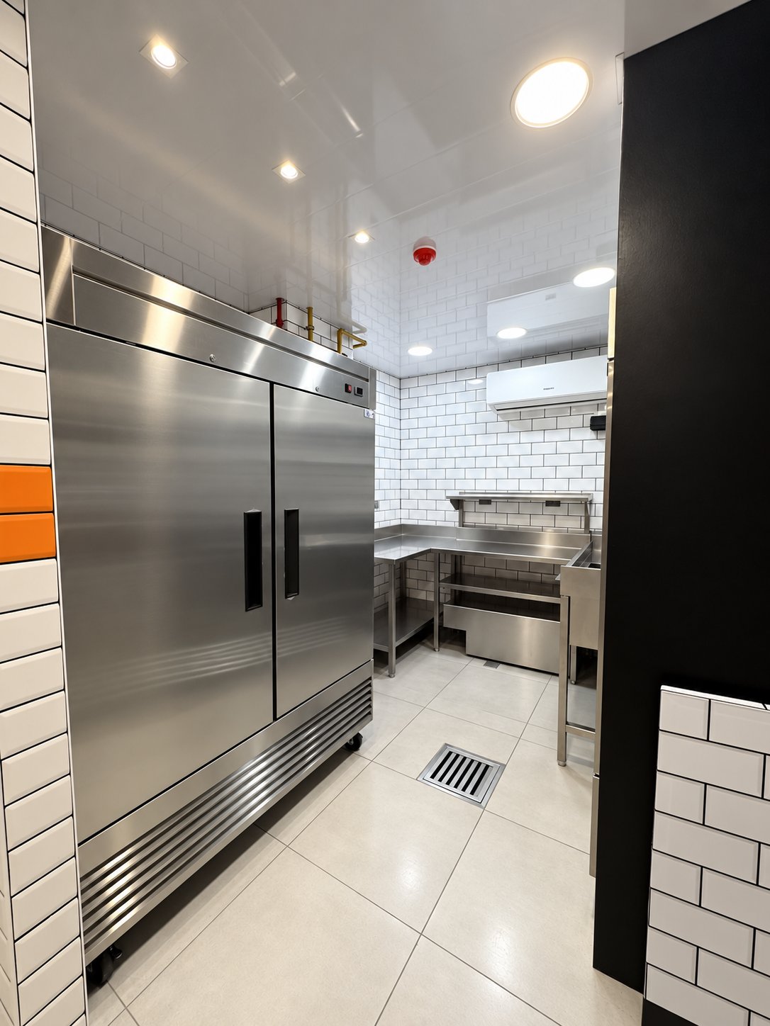 Refrigerador de dos puertas y pasillo hacia el área de preparación