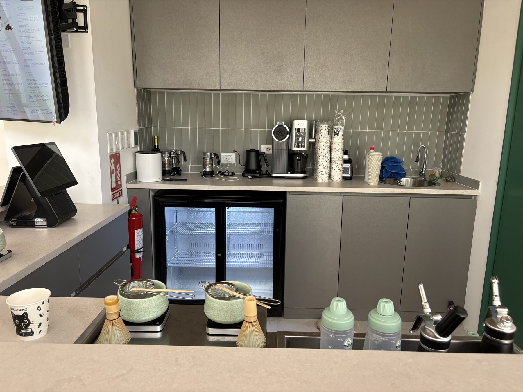 Área de bar con estación de matcha y expositor de puerta de vidrio