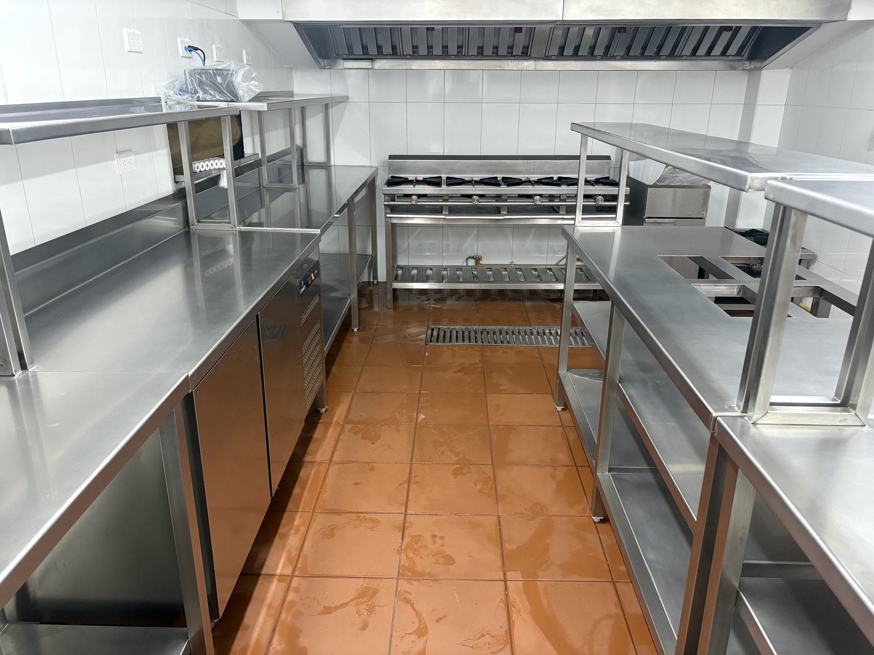 Cocina de Sambolón La Joya con línea de cocción, campana y mesas de acero inoxidable